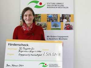 Einen symbolischen Förderscheck in Höhe von 2.526.524,68 Euro hat Christiane Overkamp, Geschäftsführerin der Stiftung Umwelt und Entwicklung Nordrhein-Westfalen, den 30 neuen Förderprojekten überreicht. Foto: Stiftung Umwelt und Entwicklung Nordrhein-Westfalen