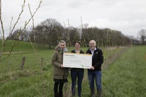 Projektleiterin Frauke Ganswind (links) und Vorsitzende der AbL NRW Anne Rothkranz-Pott weihen mit der Übergabe des symbolischen Förderschecks durch Frank Griesel von der Stiftung Umwelt und Entwicklung Nordrhein-Westfalen die erste Agroforstanlage des Projekts ein.