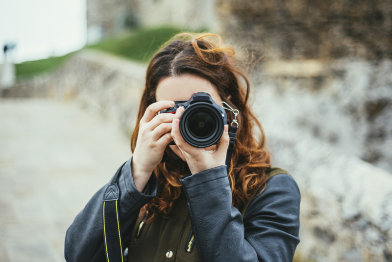 Young woman using DSLR camera (Foto: istock/MarioGuti)
