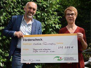 Frank Griesel von der Stiftung Umwelt und Entwicklung Nordrhein-Westfalen überreicht OroVerde-Vorständin Martina Schaub den symbolischen Förderscheck.